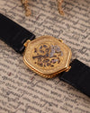 Close-up of hand-engraved 14K gold skeleton dial on Audemars Piguet watch, revealing open-worked manual movement
