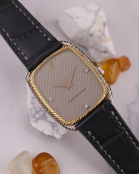 Close-up of silver dial with diagonal texture and diamond markers at 3, 6, and 9 o’clock on Audemars Piguet dress watch