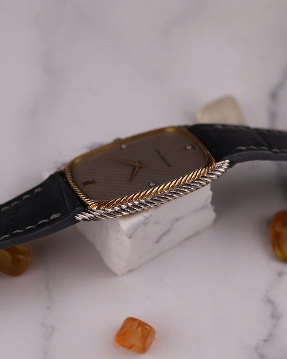 Side profile of Audemars Piguet ultra-thin watch showing slim two-tone case and braided bezel edge
