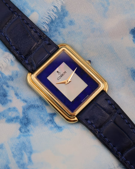 Front view of Corum 18K yellow gold tank watch with mother-of-pearl and lapis lazuli dial