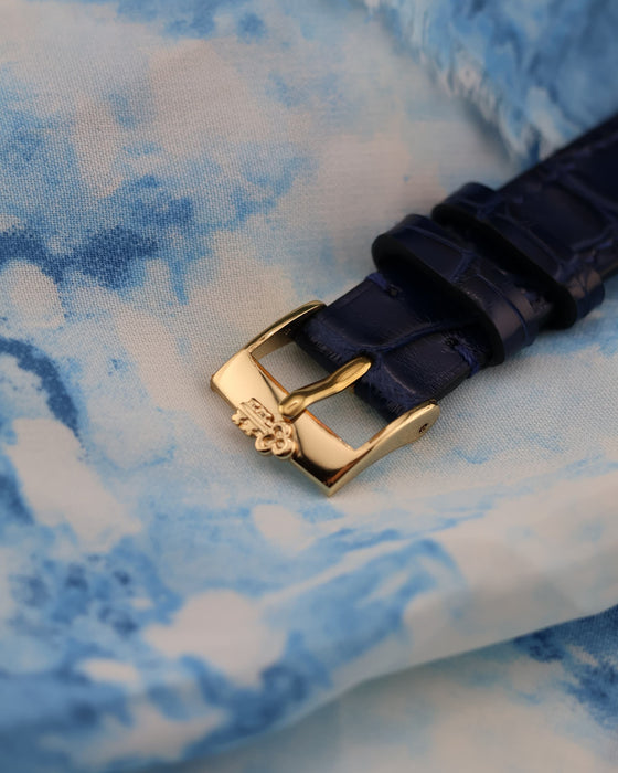 Top view of original Corum-signed 18K yellow gold buckle on leather strap