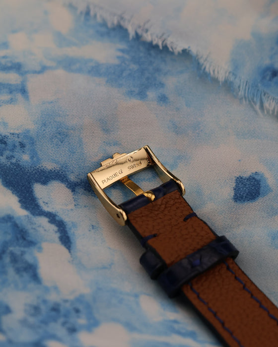 Underside view of Corum buckle in 18K gold with strap detail