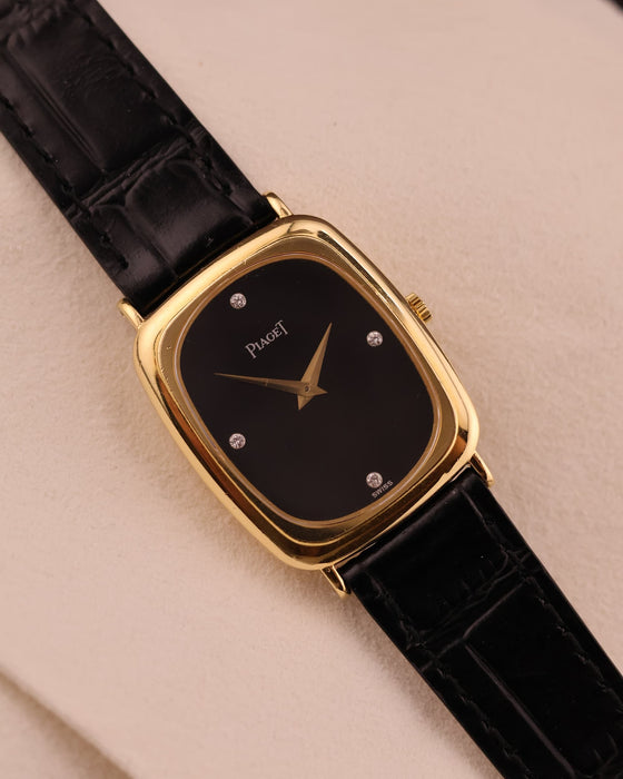 Front view of vintage Piaget dress watch with black onyx dial, diamond markers, and 18K yellow gold case.