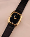 Alternate front angle of Piaget watch showcasing the sleek onyx dial and polished gold case.