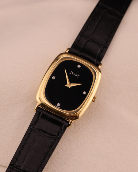 Alternate front angle of Piaget watch showcasing the sleek onyx dial and polished gold case.