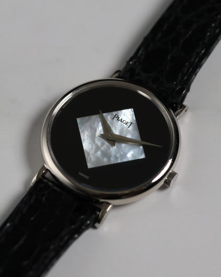 Close-up of the Piaget Ref. 922 dial featuring a diamond-shaped mother of pearl inlay set against a glossy black onyx background with silver dauphine hands.