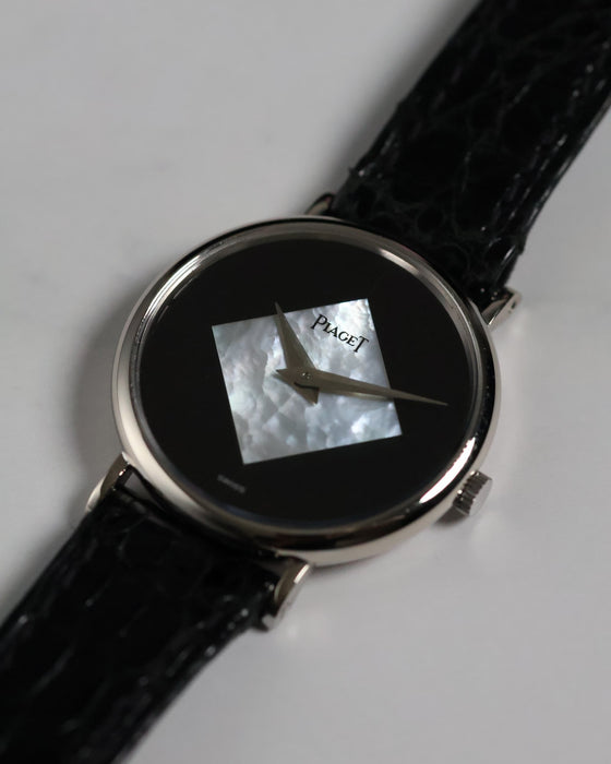Close-up of the Piaget Ref. 922 dial featuring a diamond-shaped mother of pearl inlay set against a glossy black onyx background with silver dauphine hands.