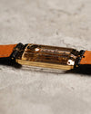 Side profile of the Corum Golden Bridge 13150, showing the slim rectangular 18k yellow gold case and the transparent sapphire construction that reveals the linear bridge movement within.