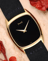 Piaget Ref. 9591 in 18k yellow gold with minimalist black lacquer dial and gold dauphine hands, cushion-shaped case.