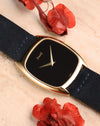 Piaget 9591 photographed at an angle, highlighting the glossy dial surface and slim case profile with suede strap.