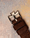 Vacheron Constantin platinum Maltese cross buckle on brown textured leather strap, emphasizing craftsmanship and design continuity.