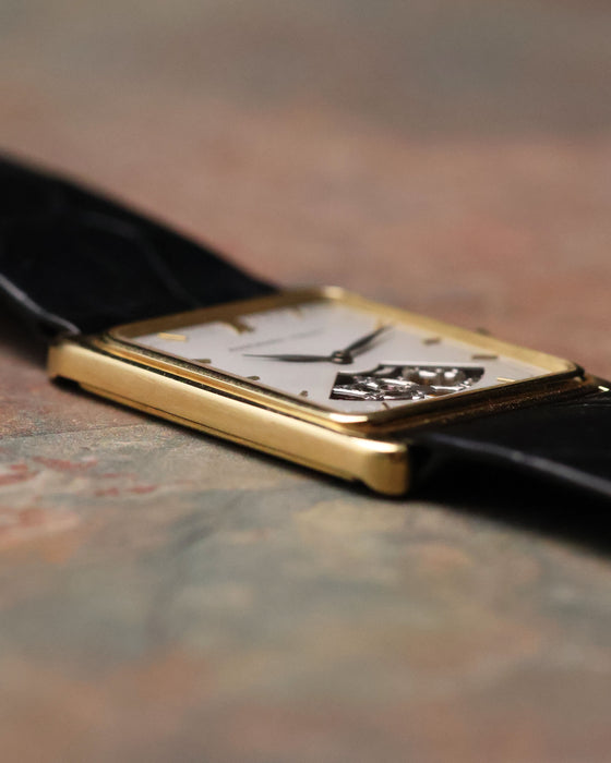 Side profile of Audemars Piguet Skeleton Aperture Tank showing slim 18K yellow gold case and curved sapphire crystal.