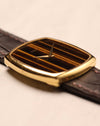 Oblique perspective of Piaget Ref. 9741 emphasizing the curvature of the gold case and the vertical Tiger’s Eye dial pattern.