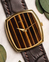 Close-up of Piaget Ref. 9741 watch featuring a vertical Tiger’s Eye dial and 18K yellow gold case, paired with a brown leather strap.