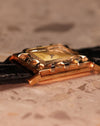 Low-angle side view of the LeCoultre Art Deco tank watch displaying its sculpted lugs and polished gold case.