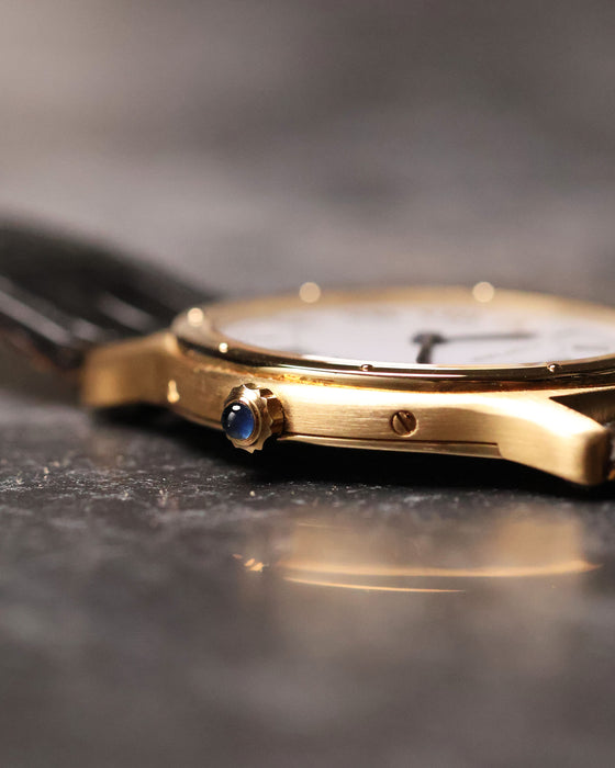 Macro side view of the Cartier Arcade LM Ref. 9605 showing the blue cabochon crown and case flank.