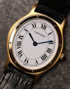 Close-up front view of the Cartier Arcade LM Ref. 9605 with its white dial, Roman numerals and gold bezel.