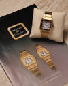Cartier Santos Carrée Ref. 2960 in 18K yellow gold resting on a cushion, photographed beside a vintage ‘Les Must de Cartier’ Santos brochure featuring two gold Santos models.