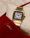 Cartier Santos Carrée Ref. 2960 photographed with the red Cartier suede pouch partially in frame, showing the square gold bezel, Roman dial, and screw-decorated bracelet.