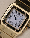 Macro close-up of the Cartier Santos Carrée dial, showing the white Roman-numeral face, chemin-de-fer minute track, blued hands, and date window at 3 o’clock.