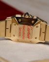 Caseback of the Cartier Santos Carrée Ref. 2960 showing the Cartier International Service sticker after recent servicing, with the gold case and bracelet partially visible.