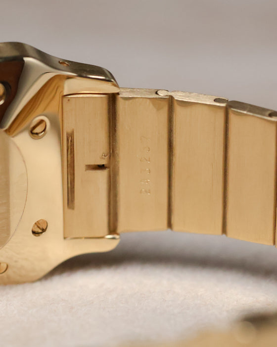 Detailed view of the serial engraving on the inside of the Cartier Santos Carrée bracelet link, emphasizing the crisp markings and brushed gold finish.
