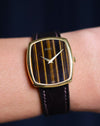 Wrist shot of Piaget Ref. 9741 watch featuring a vertical Tiger’s Eye dial and 18K yellow gold case