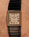 Front-facing top-down photograph of a Rolex Cellini Ref. 4015 featuring an ivory Roman numeral dial, asymmetric ribbed gold case, and black leather strap.