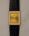 Straight-on front view of Rolex Cellini 4016 with gold dial, baton hands, and vertically fluted yellow gold case on black leather strap