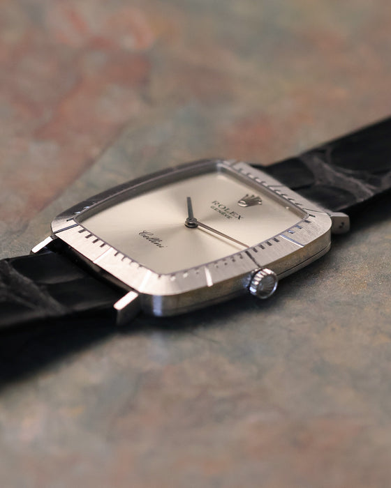 Low-angle side profile of Rolex Cellini 4087 highlighting slim white gold case, brushed bezel texture, and signed crown.