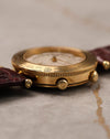 Side profile of Van Cleef & Arpels Traveller highlighting slim 18K gold case, engraved world time bezel, and signed crowns