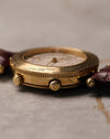 Angled side view of Van Cleef & Arpels Traveller showing dual crowns and fluted bezel edge in yellow gold