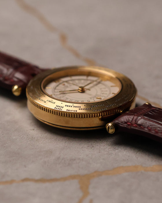 Low-profile perspective of Van Cleef & Arpels Traveller emphasizing case thickness and world time bezel engraving