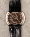 Close-up of Corum guinea fowl feather dial showing natural feather pattern and minimalist two-hand layout.