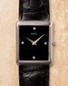 Front view of Piaget 9152 showing rectangular woven white gold case, glossy black onyx dial and four diamond hour markers.