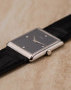 Angled side perspective showing woven 18K white gold case texture and signed crown on Piaget 9152.