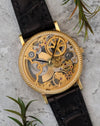 Front view of the Universal Genève skeleton watch, highlighting the openworked dial, exposed gears, and finely engraved gold bridges within a coin-edge yellow gold case.