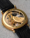 Rear three-quarter view of the micro-rotor movement, showcasing the engraved rotor, ruby jewels, and open architecture beneath the sapphire caseback.