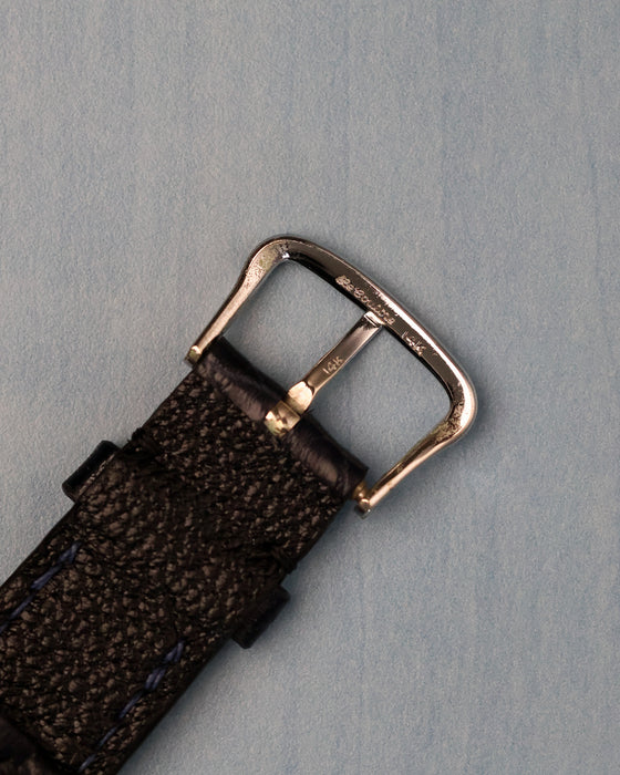 Close-up of the original 14K white-gold buckle with visible gold hallmarks