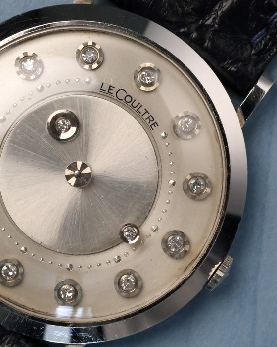 Detailed dial close-up showing diamond hour markers, minute track dots, and mystery time display