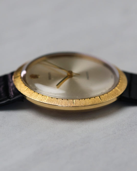 Low side view highlighting wide sloping textured bezel and thin case construction