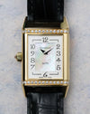 Front dial straight-on showing mother-of-pearl centre and diamond-set top and bottom case edges.