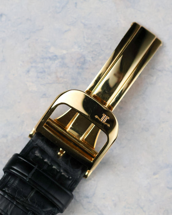 Yellow gold deployant buckle with Jaeger-LeCoultre logo on black leather strap.