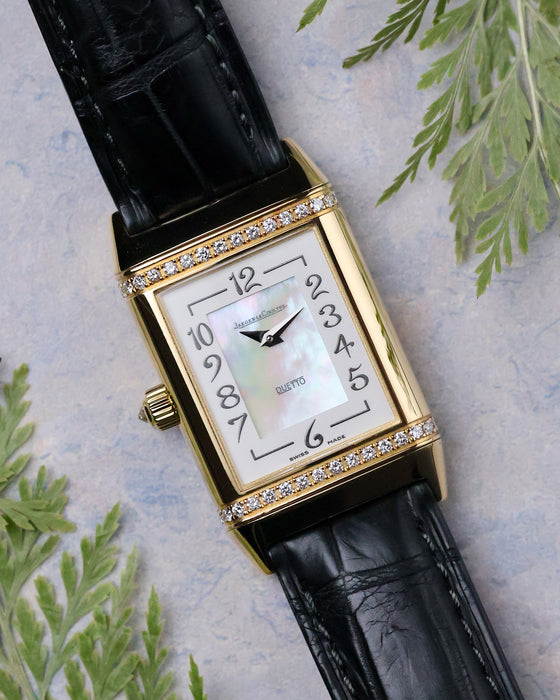 Jaeger-LeCoultre Reverso Duetto front view showing mother-of-pearl dial with Arabic numerals and diamond-set yellow gold case.