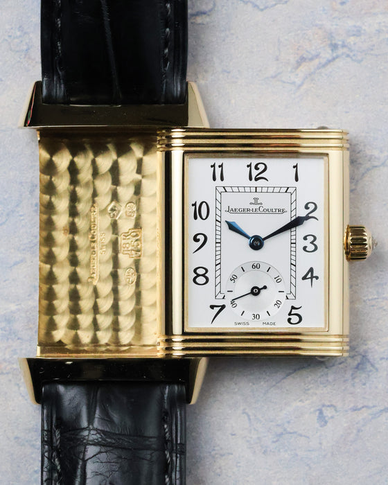 Reverse dial of the Reverso Duetto with small seconds and black Arabic numerals in a yellow gold case.