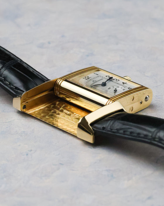 Side profile of the Reverso case showing thickness, polished yellow gold surfaces, and hinge mechanism.