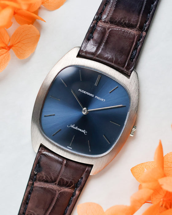 Audemars Piguet Ref. 5279 angled view with blue dial and white gold case placed beside orange flowers