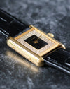 Side profile of yellow gold Cartier Tank case showing polished brancards and crown detail.