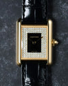 Top-down view highlighting symmetry of diamond-set dial and lacquer centre on yellow gold case.