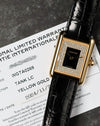 Cartier Tank LC placed over warranty card showing model and date details.